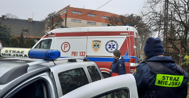 Zdjęcie przed altaną - radiowóz Straży Miejskiej, ambulans Zespołu Ratownictwa Medycznego oraz strażniczka i pracownica socjalna