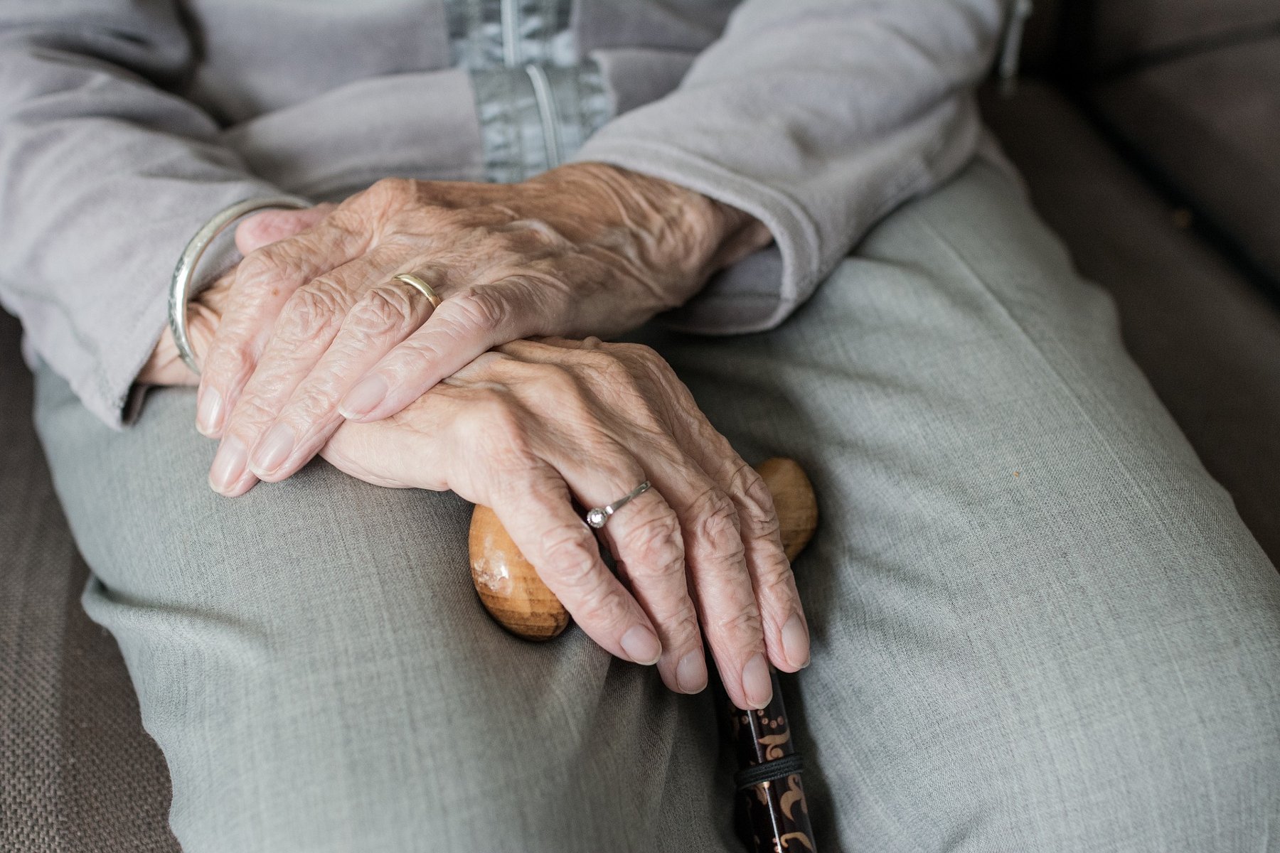 Zdjęcie przedstawią starszą osobę trzymającą w dłoniach laskę. - grafika artykułu